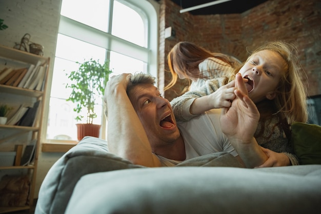 Photo family spending nice time together at home, looks happy and cheerful, lying down together