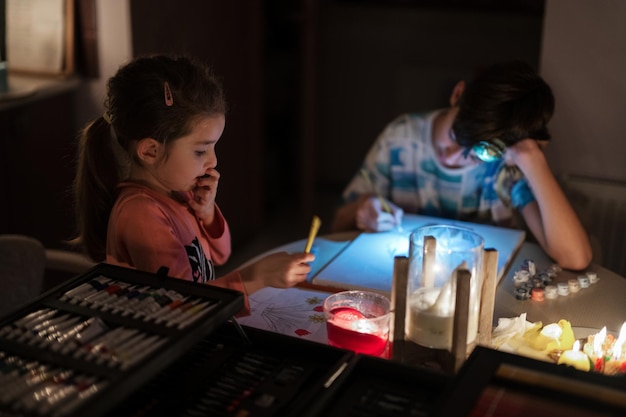 Family spending time together during an energy crisis in Europe causing blackouts Kids drawing in blackout