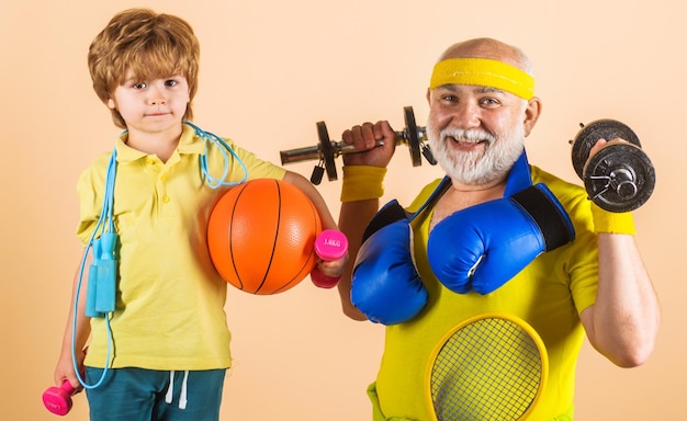 Photo family sport grandfather and kid sporting old mature man and little child boy with sport equipment