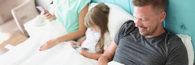 Family stare in smartphone morning in bed with devices kill time