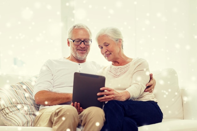 family, technology, age and people concept - happy senior couple with tablet pc computer at home