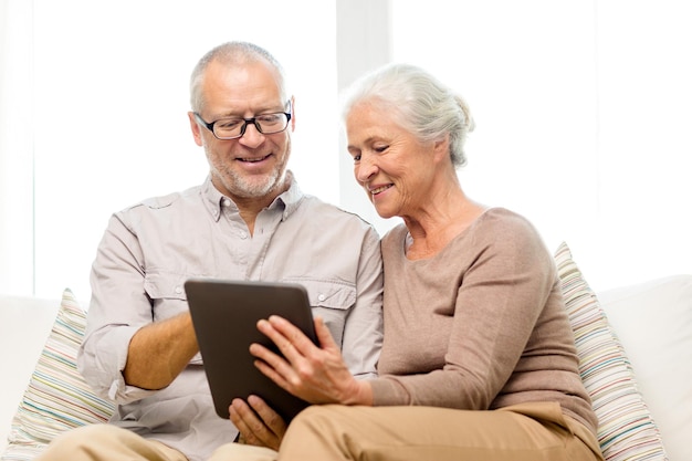 family, technology, age and people concept - happy senior couple with tablet pc computer at home