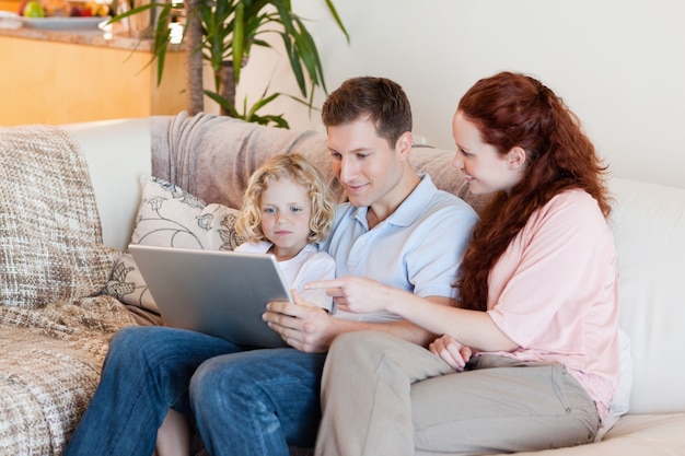 Photo family using laptop on the sofa