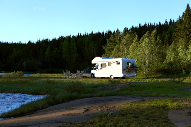 Family vacation travel, holiday trip in motorhome near the lake, Caravan car Vacation. Beautiful Nature in Norvay - natural scandinavian landscape.