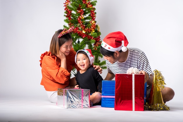 Family very happy with gift a day Christmas and Happy New Year on background in studio