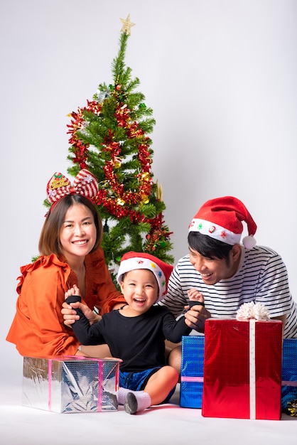 Family very happy with gift a day Christmas and Happy New Year on background in studio