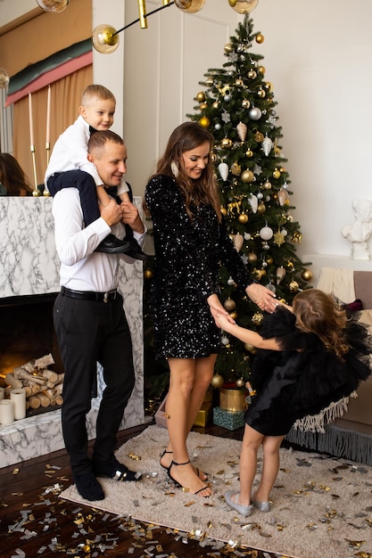 Family waiting for Christmas at home Parents and their children decorate the Christmas tree indoors