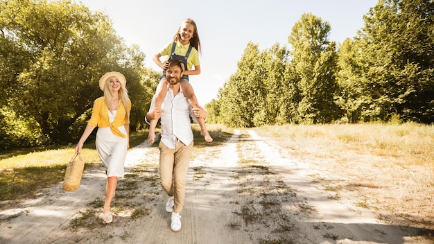 Family walk Father carrying daughter on shoulders