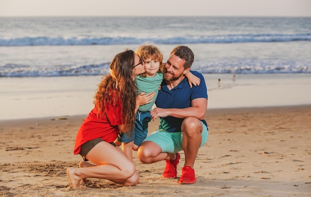 Family walking to the beach on a sunny day sea vacation parents and children hugging at ocean shore