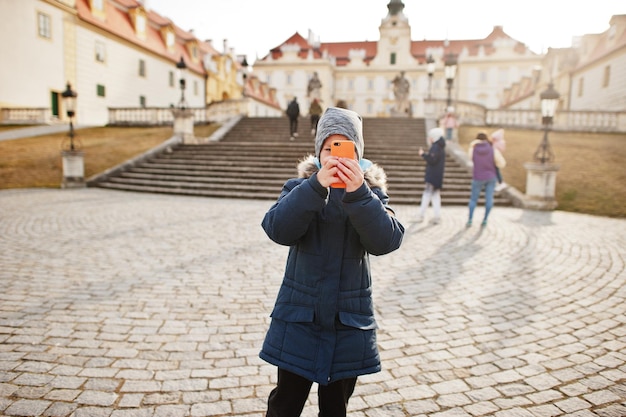 Family walking at Valtice town Czech Republic Boy makes a photo of cultural monuments by phone