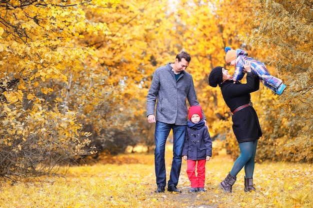 Family walking with children in autumn park in the afternoon