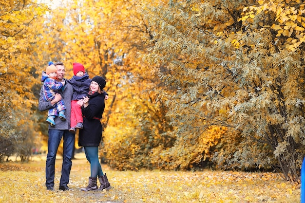 Family walking with children in autumn park in the afternoon