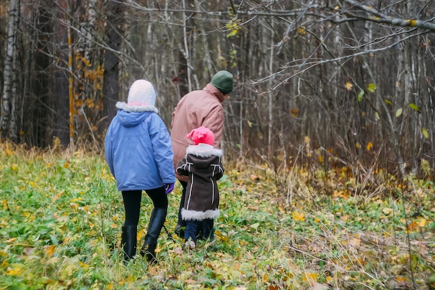 Family walks in autumn forest