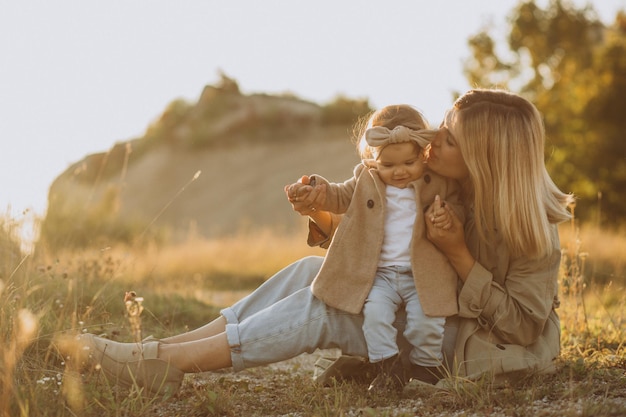 Family walks in a field Little girl child in the summer meadow Woman in a white shirt