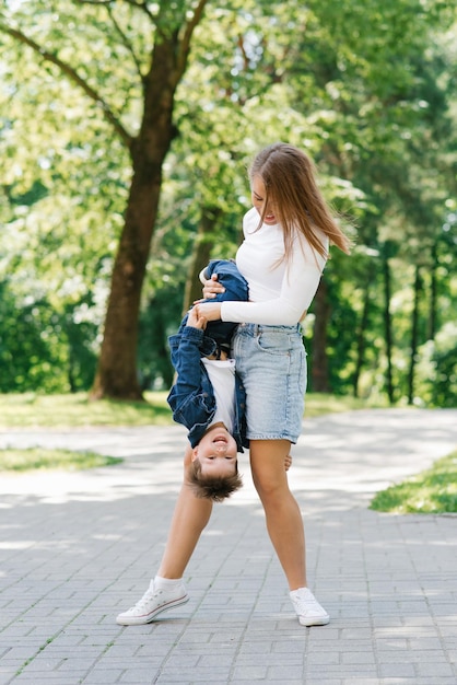 Family weekend in summer in the park for a walk Happy mom and son having fun