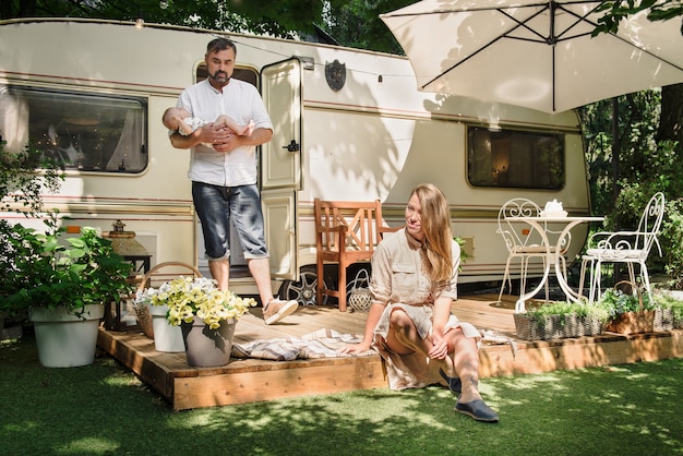 Family with baby near camper traveling and free time together