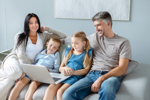 Family with children using a laptop together in their free evening