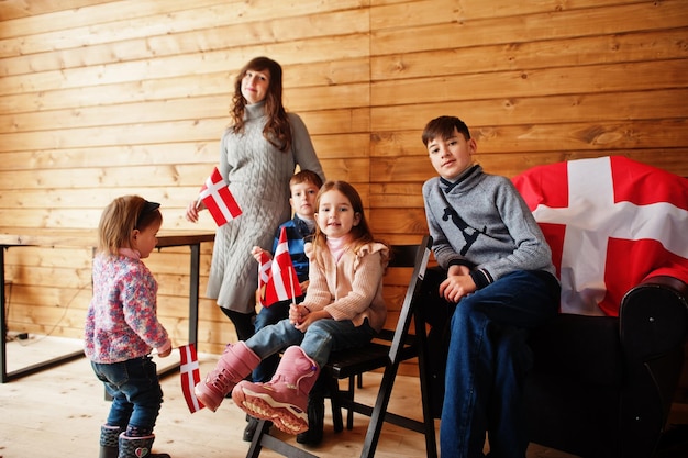 Family with Denmark flags inside wooden house Travel to Scandinavian countries Happiest danish people's