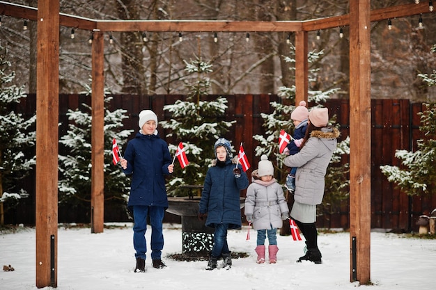 Family with Denmark flags outdoor in winter Travel to Scandinavian countries Happiest danish peoples