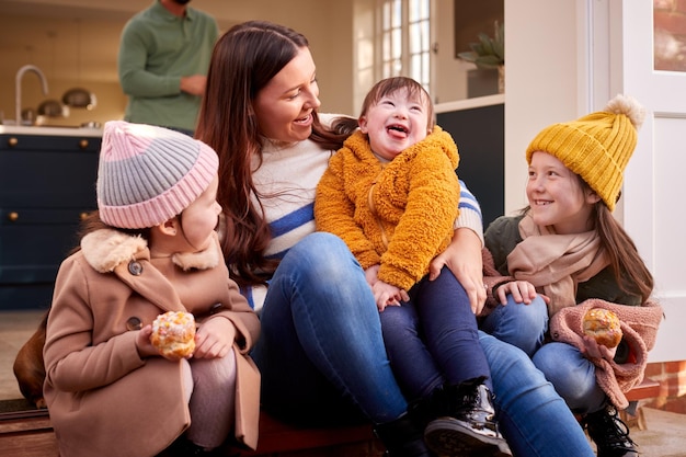 Family With Down Syndrome Daughter Getting Ready To Go For Autumn Or Winter Walk Together