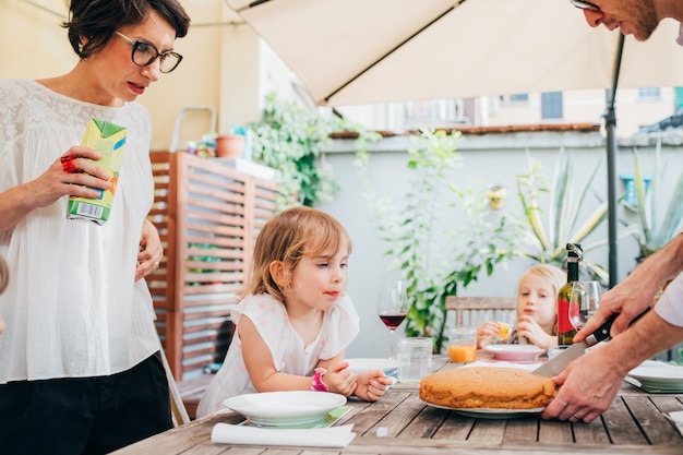 Family with female children outdoor sitting table having breakfast