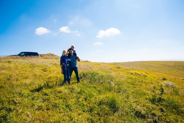 Family with kid hiking in mountains after car