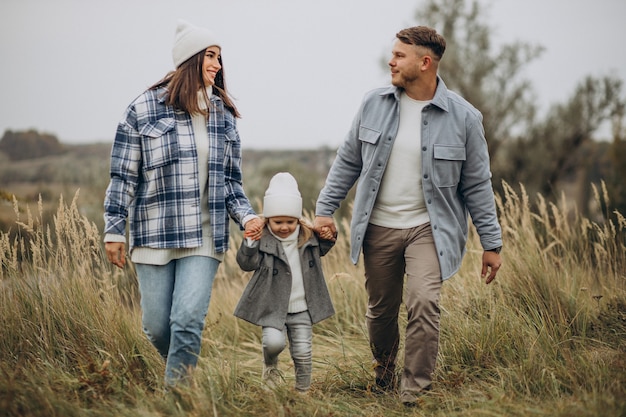 Family with little daughter together in autumnal weather having fun