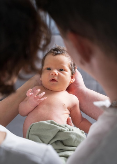 family with a newborn child Mom and dad look tenderly at the child Viewing through parents to baby