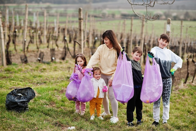 Family with trash bag collecting garbage while cleaning in the vineyards Environmental conservation and ecology recycling