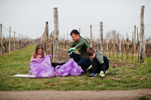 Family with trash bag collecting garbage while cleaning in the vineyards Environmental conservation and ecology recycling