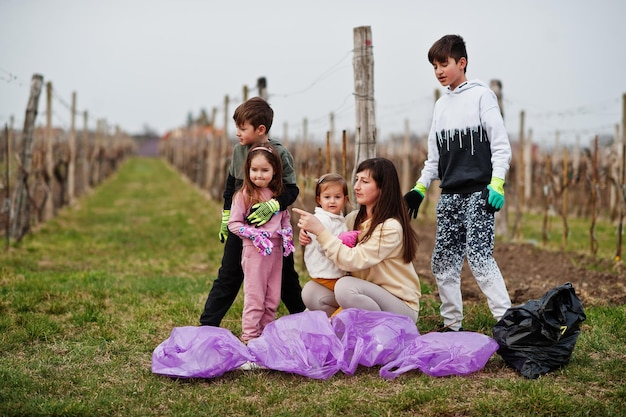 Family with trash bag collecting garbage while cleaning in the vineyards Environmental conservation and ecology recycling