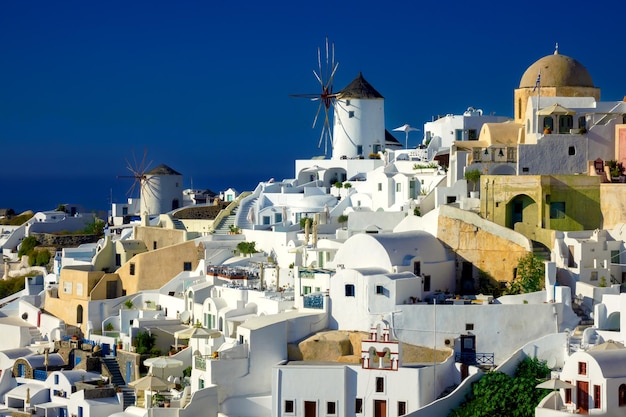 Famous windmills and cityscape of Oia town on Santorini island in Greece Traditional white houses Greece Aegean Sea Popular European