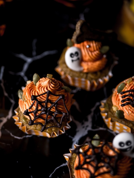 Fancy Halloween food Party Table with Pumpkin Cupcake Muffin and cookies.