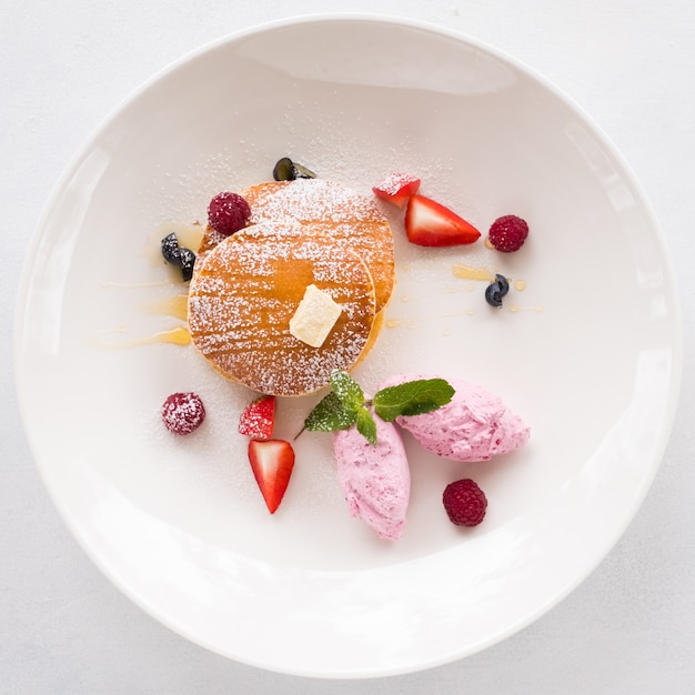 Fancy restaurant breakfast dessert. Sweet fruit pancakes on white plate. Haute cuisine concept