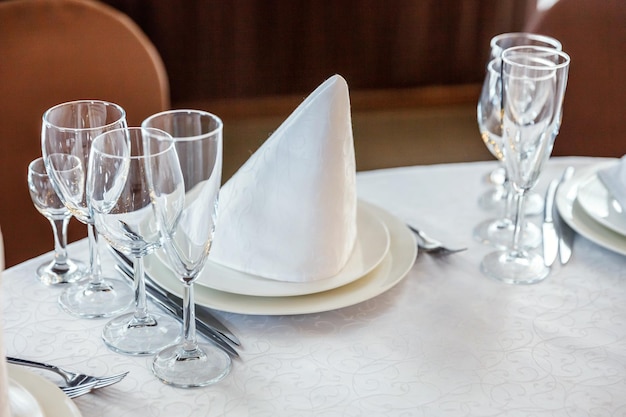 Fancy table set for dinner with napkin glasses in restaurant luxury interior background wedding eleg