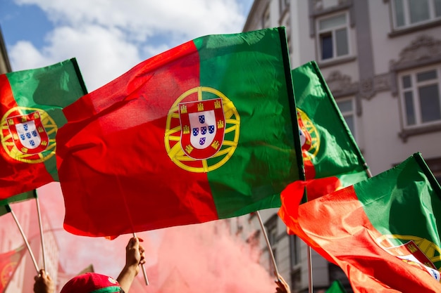 Photo fans waving portuguese flags at outdoor event