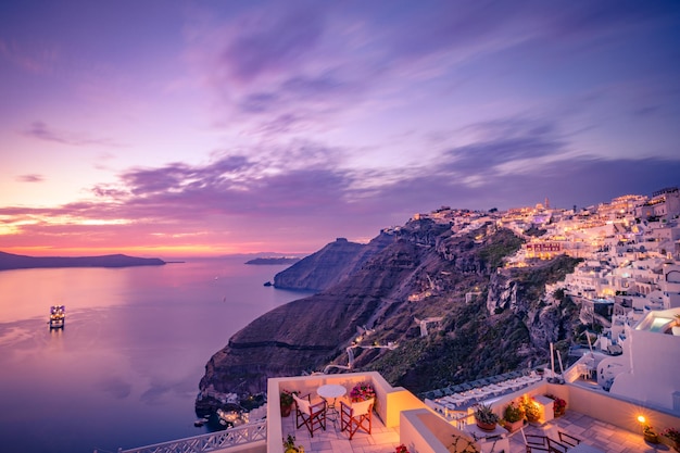 Fantastic evening view of Fira, caldera, volcano of Santorini, Greece with cruise ships at sunset