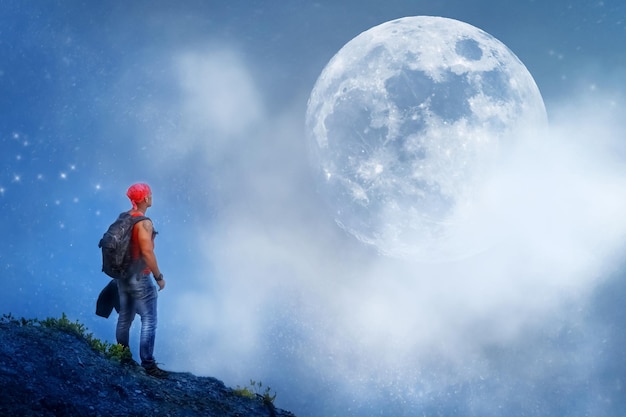 Fantastic space travel concept Earthman against the background of the starry sky and the huge moon