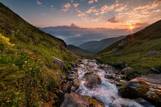 Fantastic sunrise over highlands stream, beautiful clouds in sky, mountain landscape