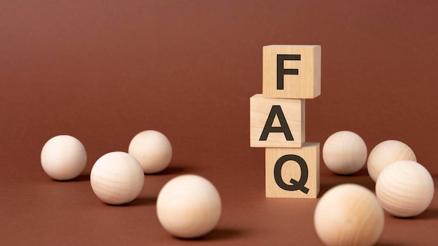 FAQ Frequency Asked Questions letter pices on the wooden cubes brown background