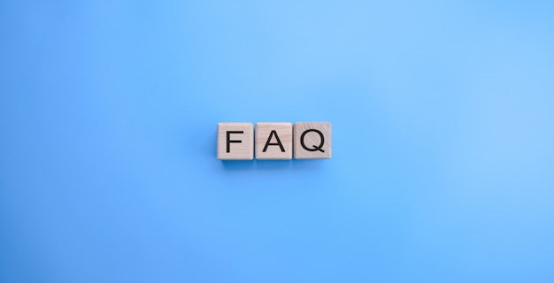 FAQ word on the wooden cubes on blue background