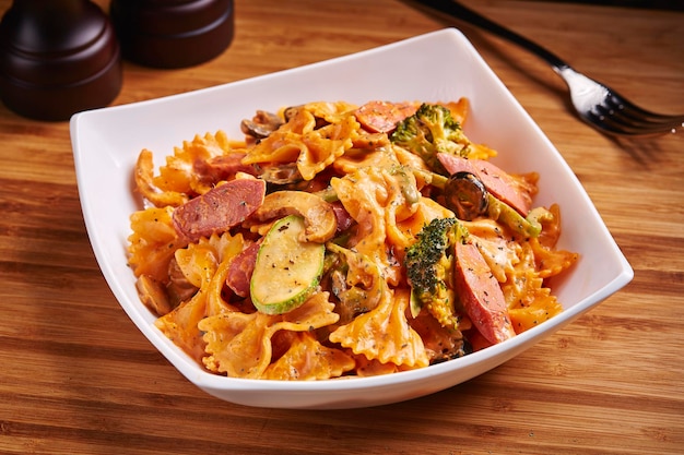 Farfalle Chicken Sausage served in dish isolated on table side view of middle east food