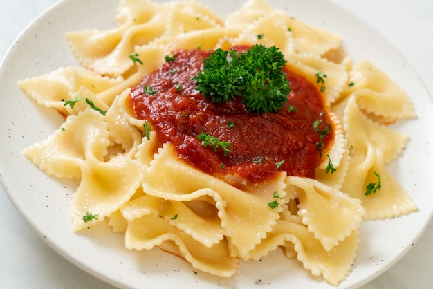 Photo farfalle pasta in tomato sauce with parsley - italian food style