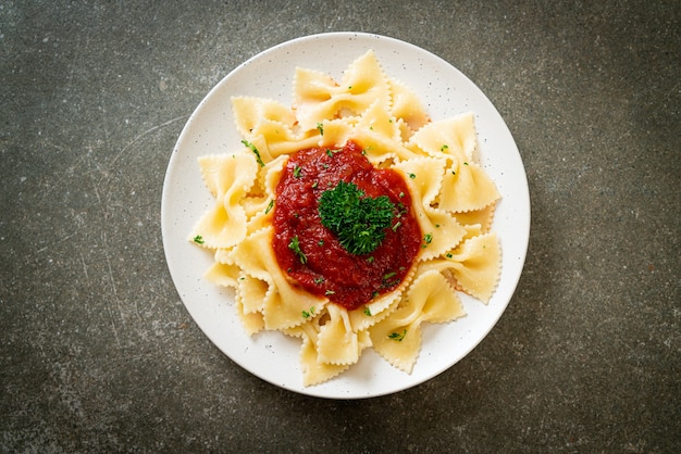 Photo farfalle pasta in tomato sauce with parsley - italian food style