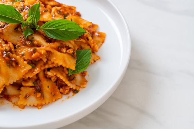 Farfalle pasta with basil and garlic in tomato sauce