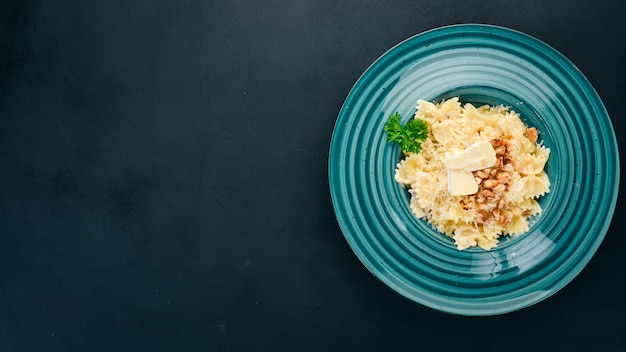 Farfalle pasta with brie cheese and nuts Italian cuisine On a wooden background Top view Copy space