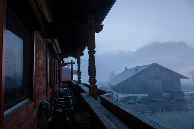 A farm building in the Austrian mountains is covered in thick fog