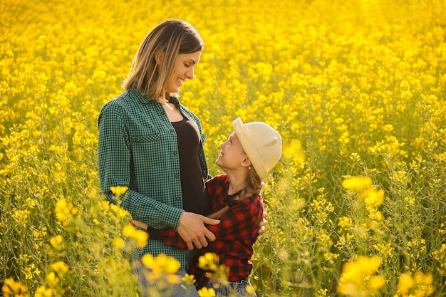 Farmer family mother and daughter embracing in summer shirt laughing and smiling at sunset side view