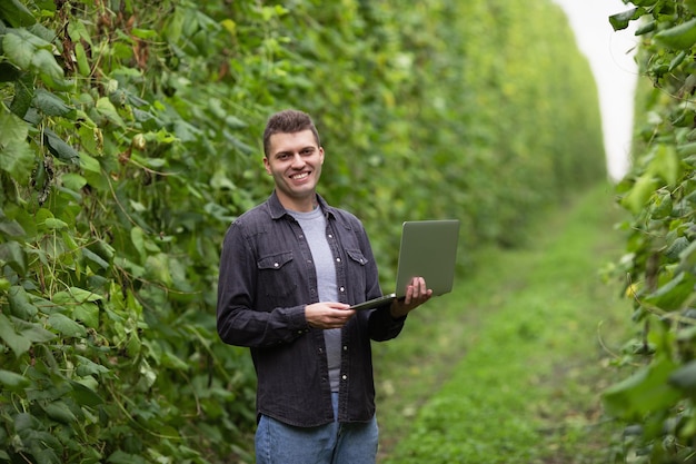 A farmer on a green field looks at the camera and smiles Happy farmer