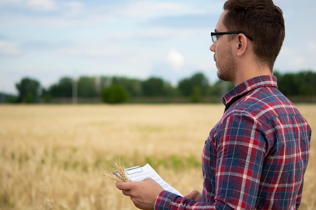 Farmer holding phone and wheat Agronomist uses online data management software